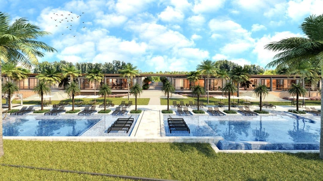 Área comum externa do loteamento, com amplas piscinas em configurações diversificadas e paisagismo tropical com palmeiras.